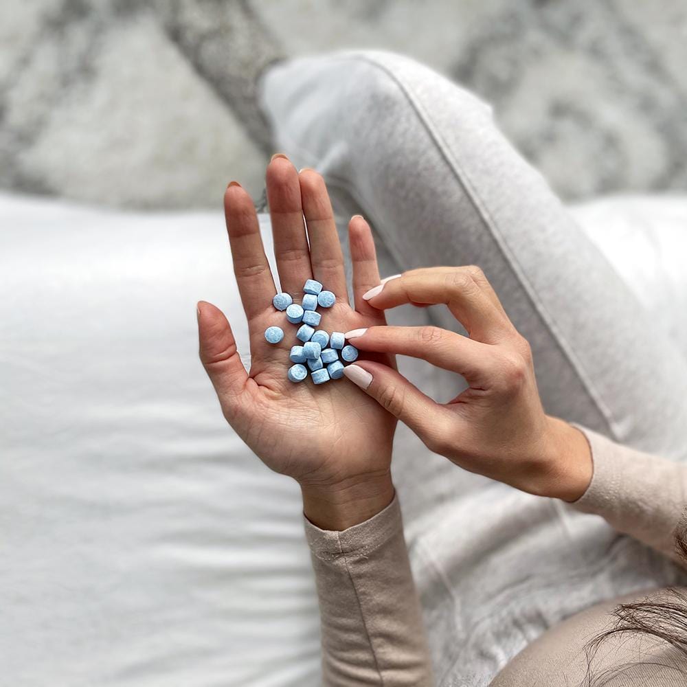 A woman holding numerous Active Wow Natural Mouthwash Tabs in her hands