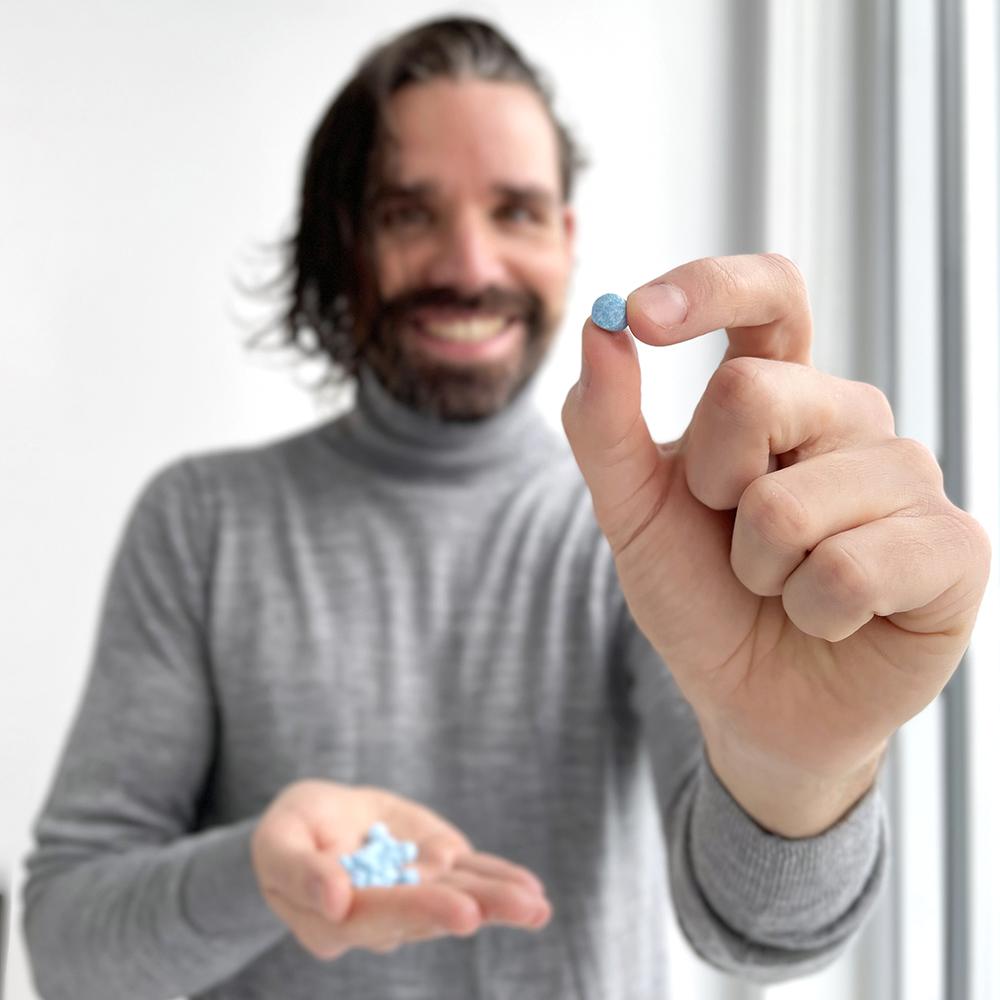 A man holding some  Active Wow Natural Mouthwash Tabs in his hands
